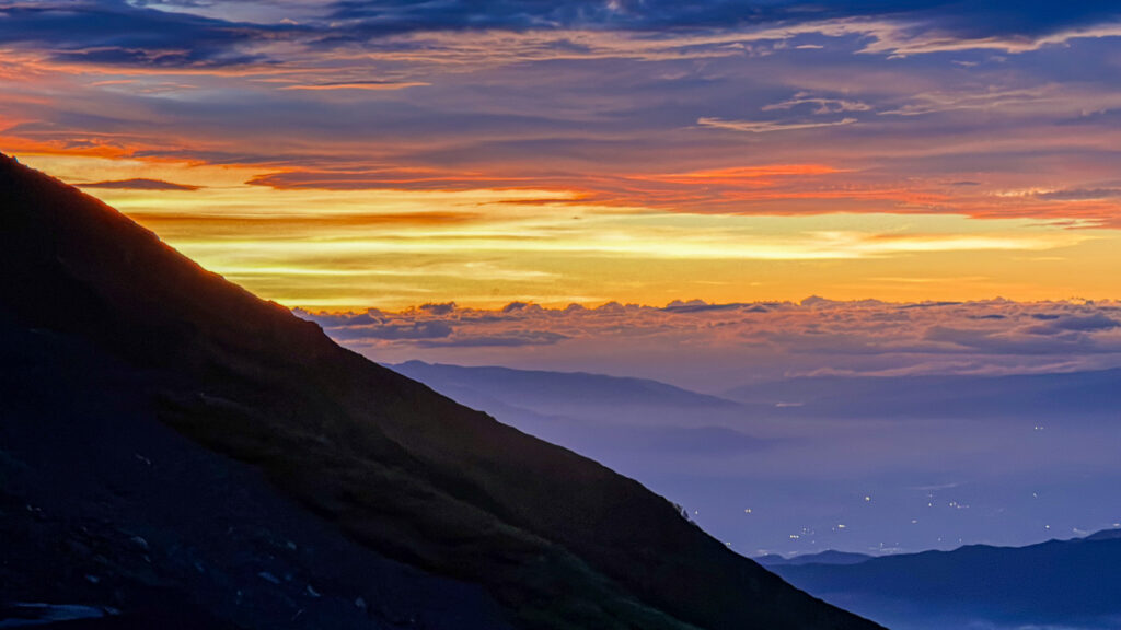 View of an orange sunset over the clouds from Mt Fuji (Japan) 7th station on a summer evening.